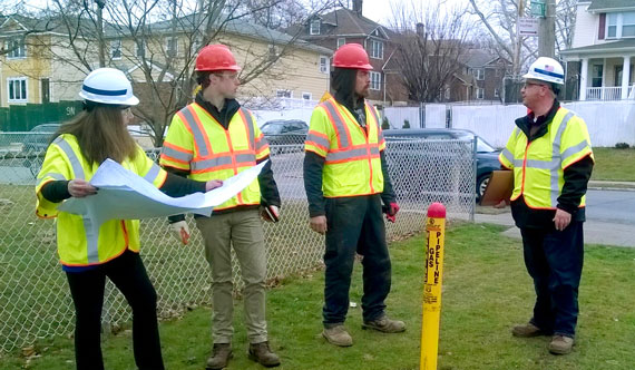 National Grid representatives meeting with contractors near pipeline marker