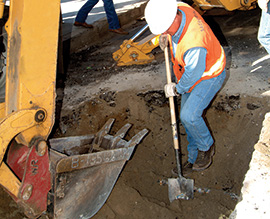 Backhoe digging and worker