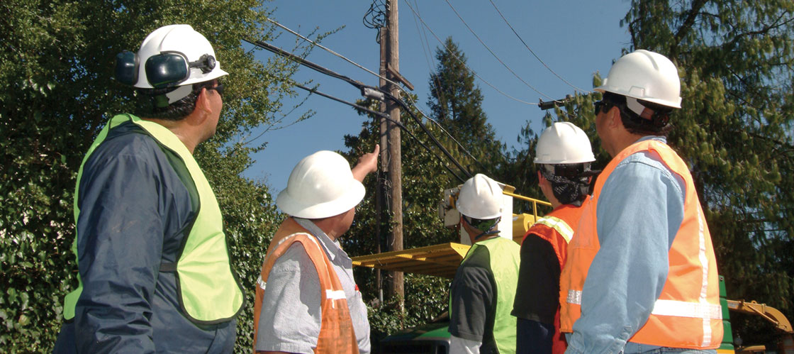 Construction workers looking at overhead power lines