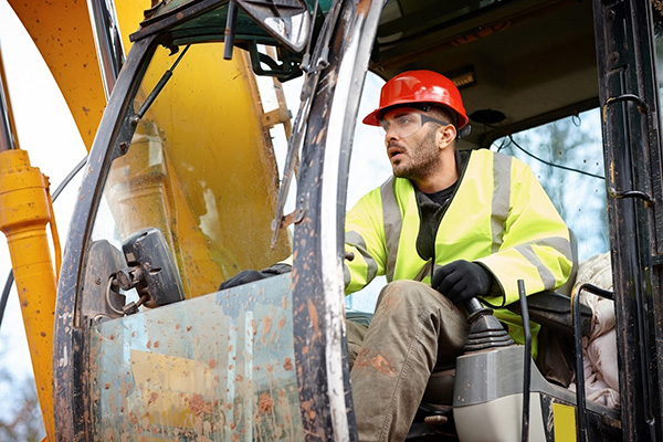 Worker operating excavator